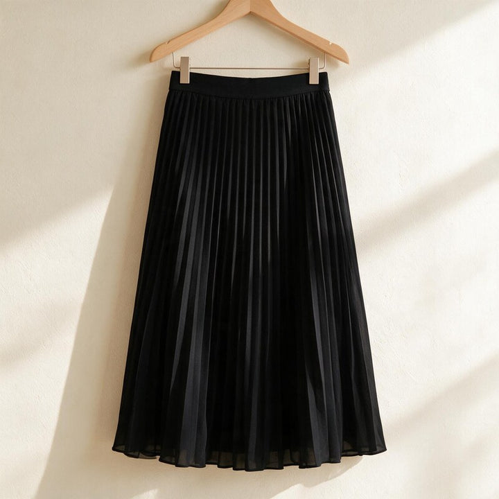 Lucy Melbourne pleated midi skirt in Black – hanging on a wooden hanger