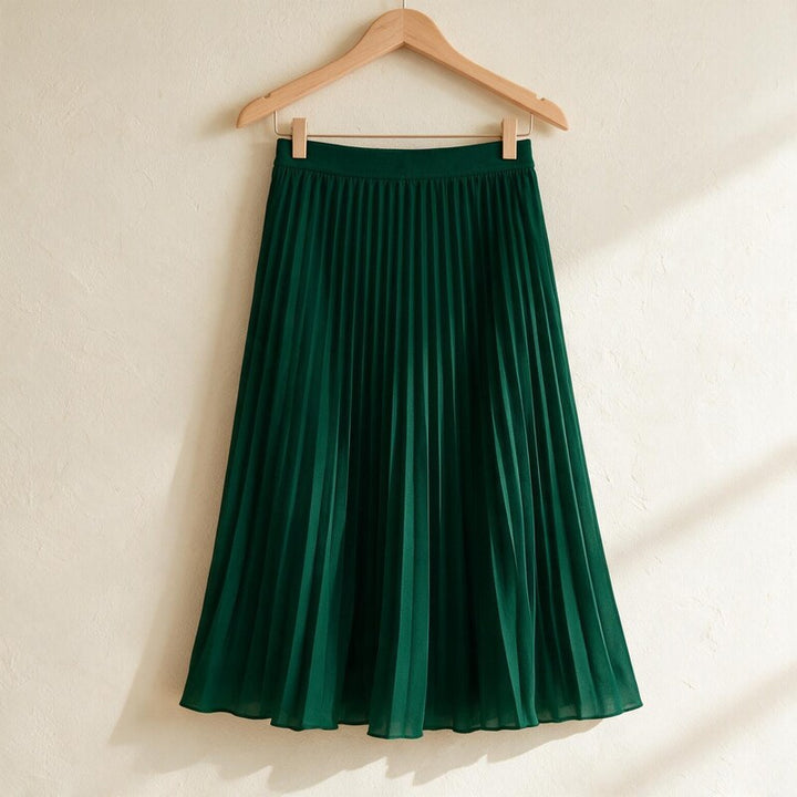 Lucy Melbourne pleated midi skirt in Dark Green – hanging on a wooden hanger